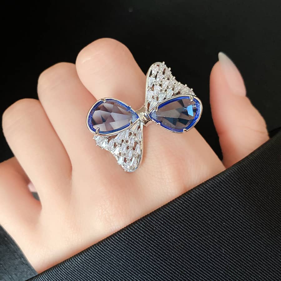 Stunning blue zircon bow ring designed by 5 Senses with intricate detailing and vibrant gemstones