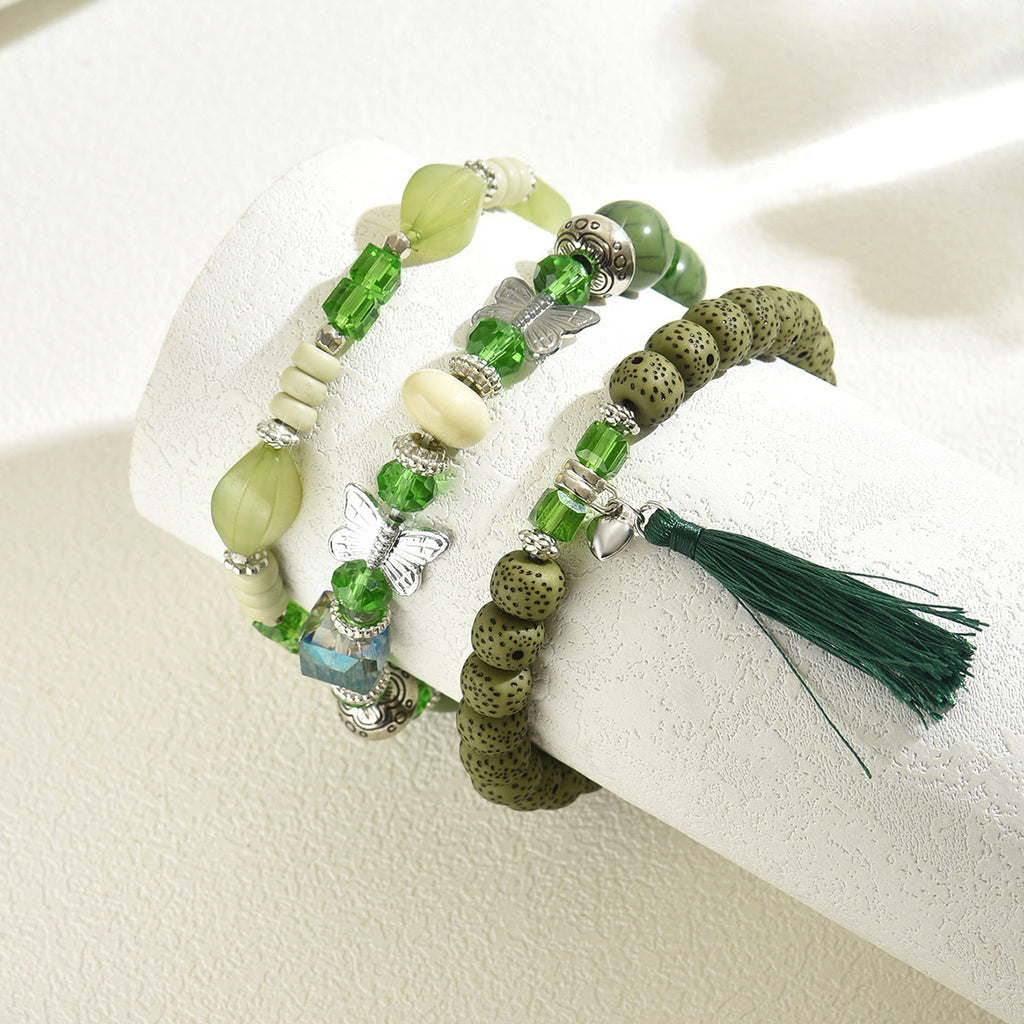 Green beaded bracelet trio with tassel lava beads butterfly charm and silver spacer accents for layering