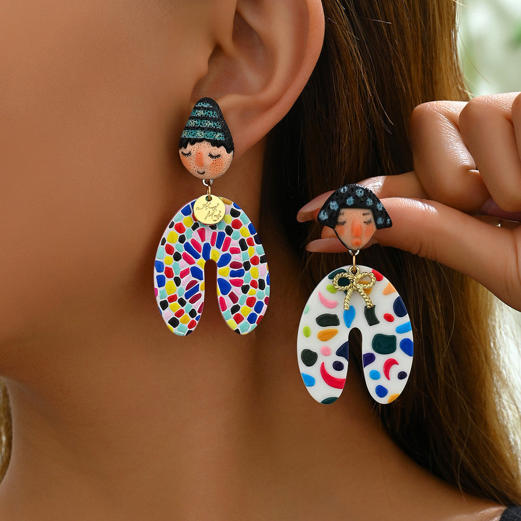 Close up of woman wearing colorful Indian doll earrings with hand painted doll faces and multicolor mosaic drops