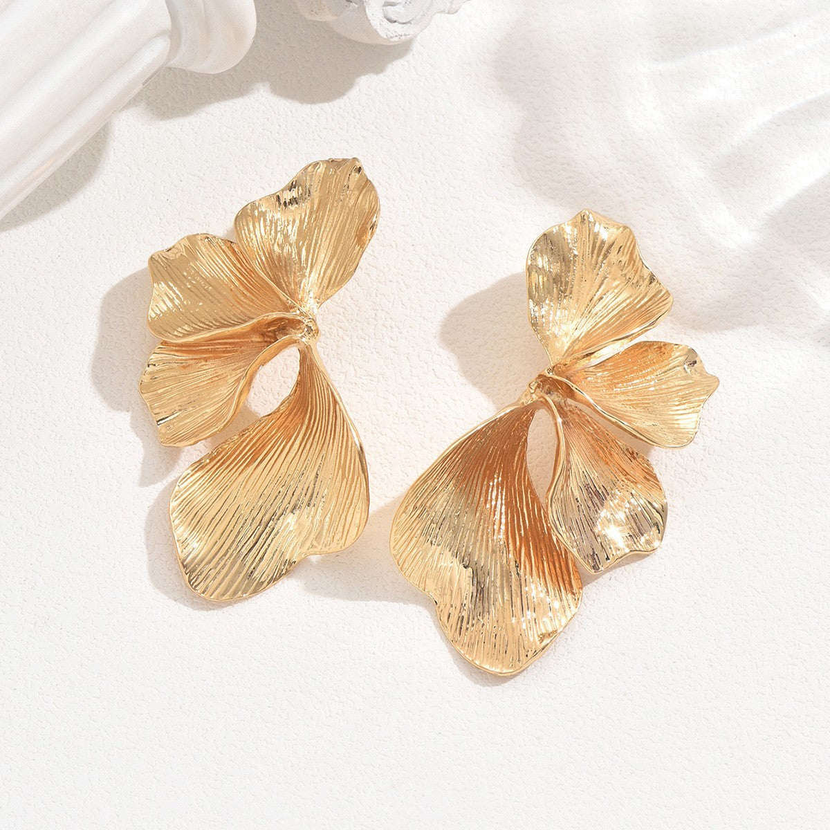 Bold gold flower earrings with textured petals in an elegant floral design