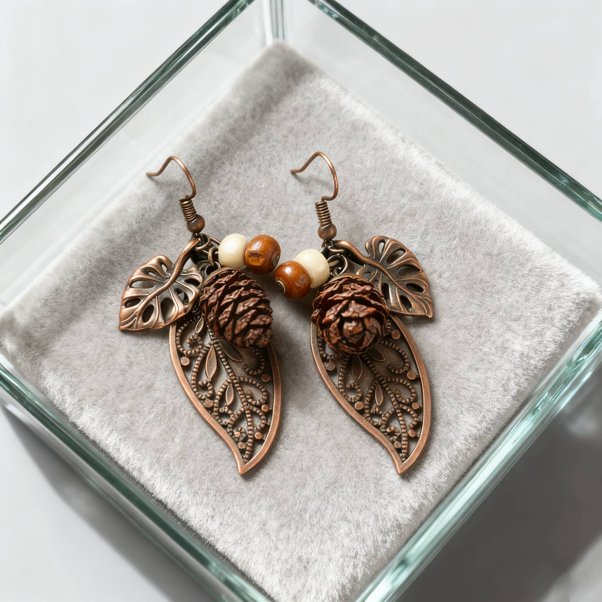 Botanical earrings with pinecone featuring intricate leaf details and decorative beads