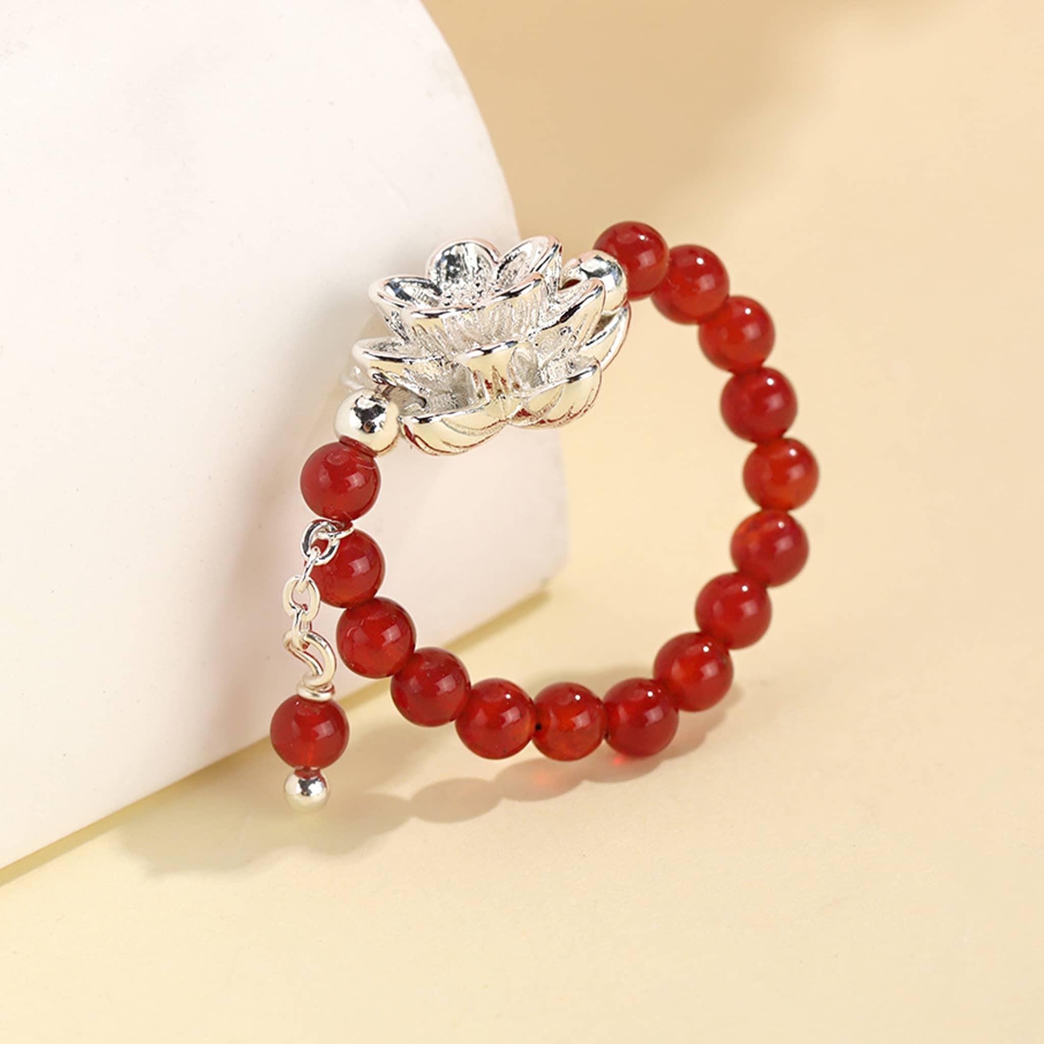 Elegant carnelian anxiety relief ring featuring a silver lotus flower design with a beaded red band