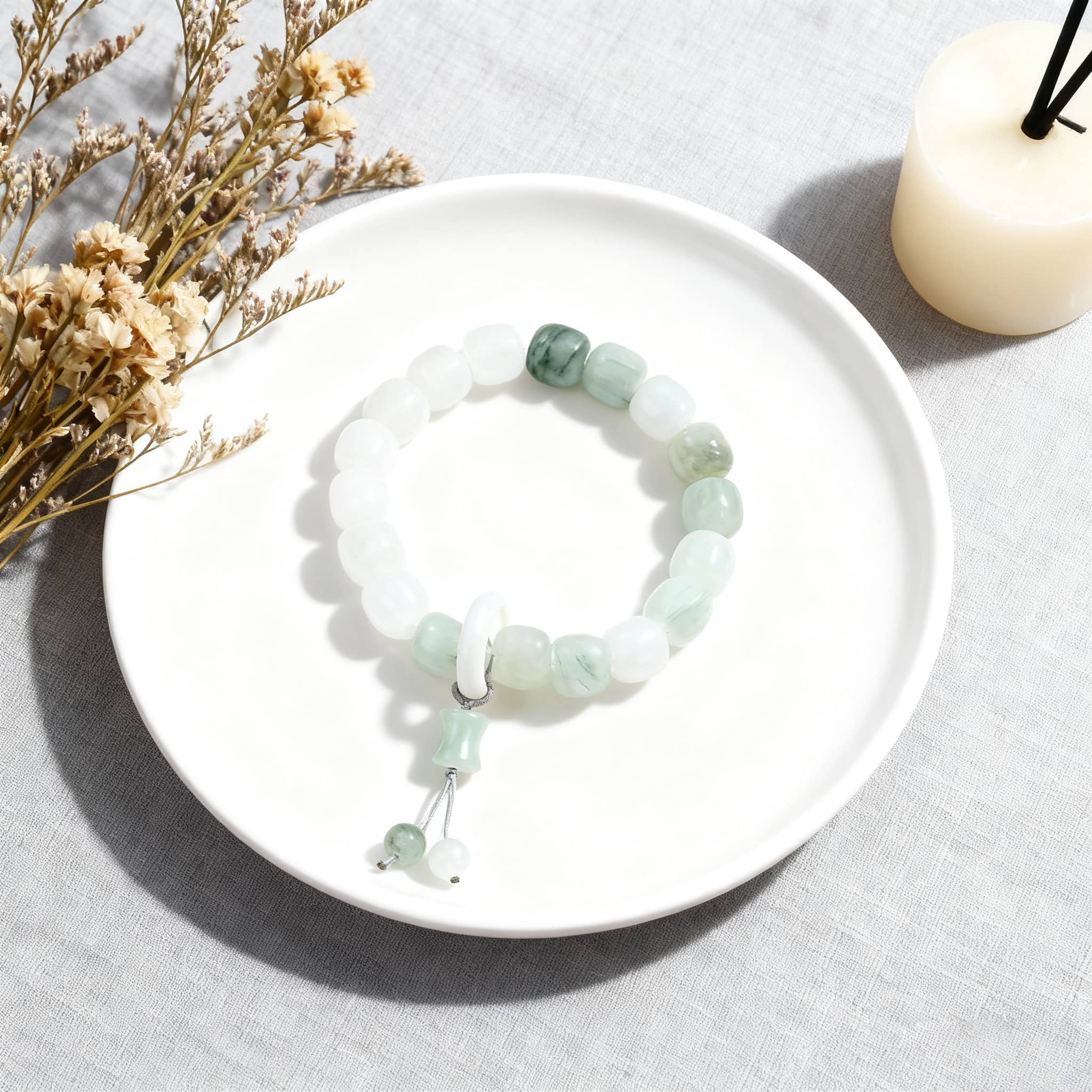 Celestial jade healing bracelet on a plate, featuring calming green and white beads.