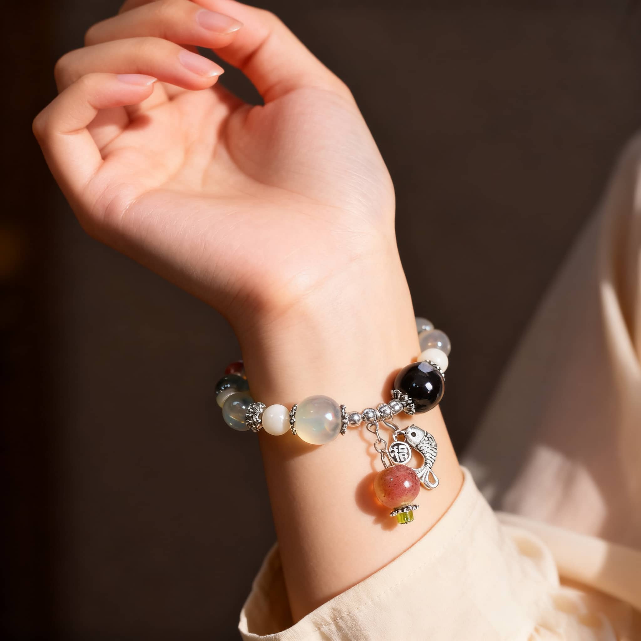 Stylish ceramic persimmon bracelet with white and black beads on a textured fabric background