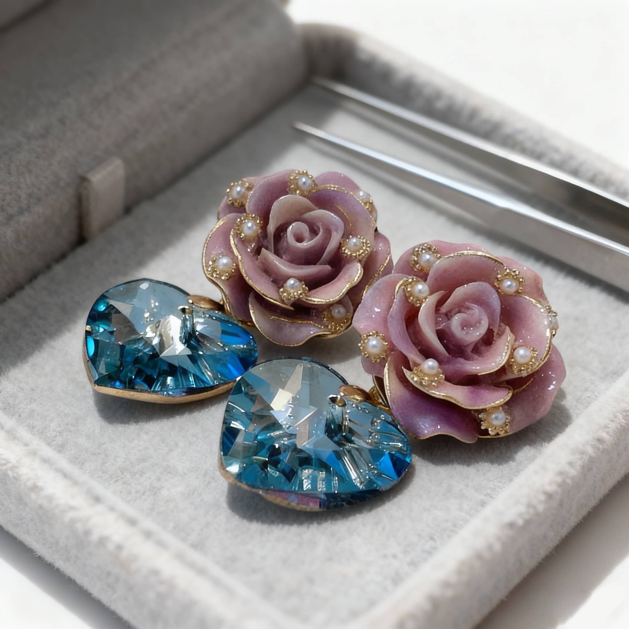 Ceramic rose zircon earrings in purple and blue with pearl accents in a jewelry box