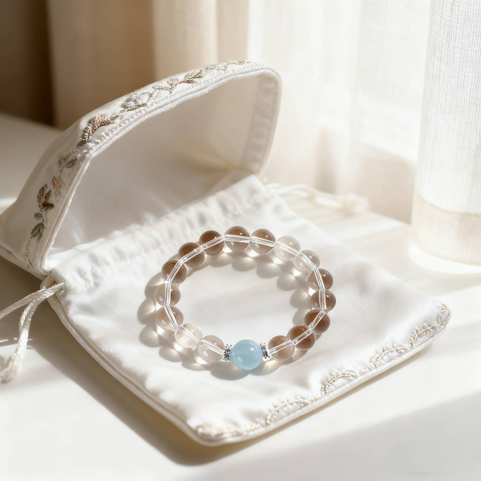 Anxious Bracelet featuring clear quartz and aquamarine jewelry on an elegant pouch
