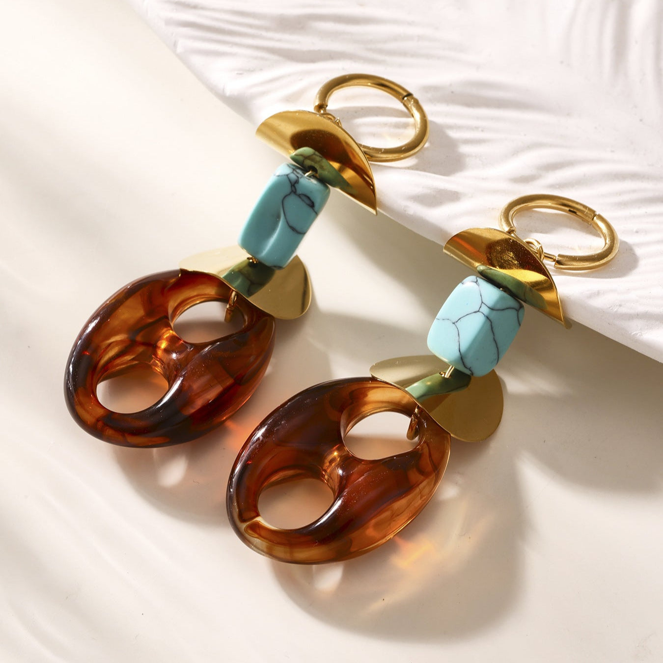 Calm oval resin stud earrings with turquoise and gold metal accents in a modern design
