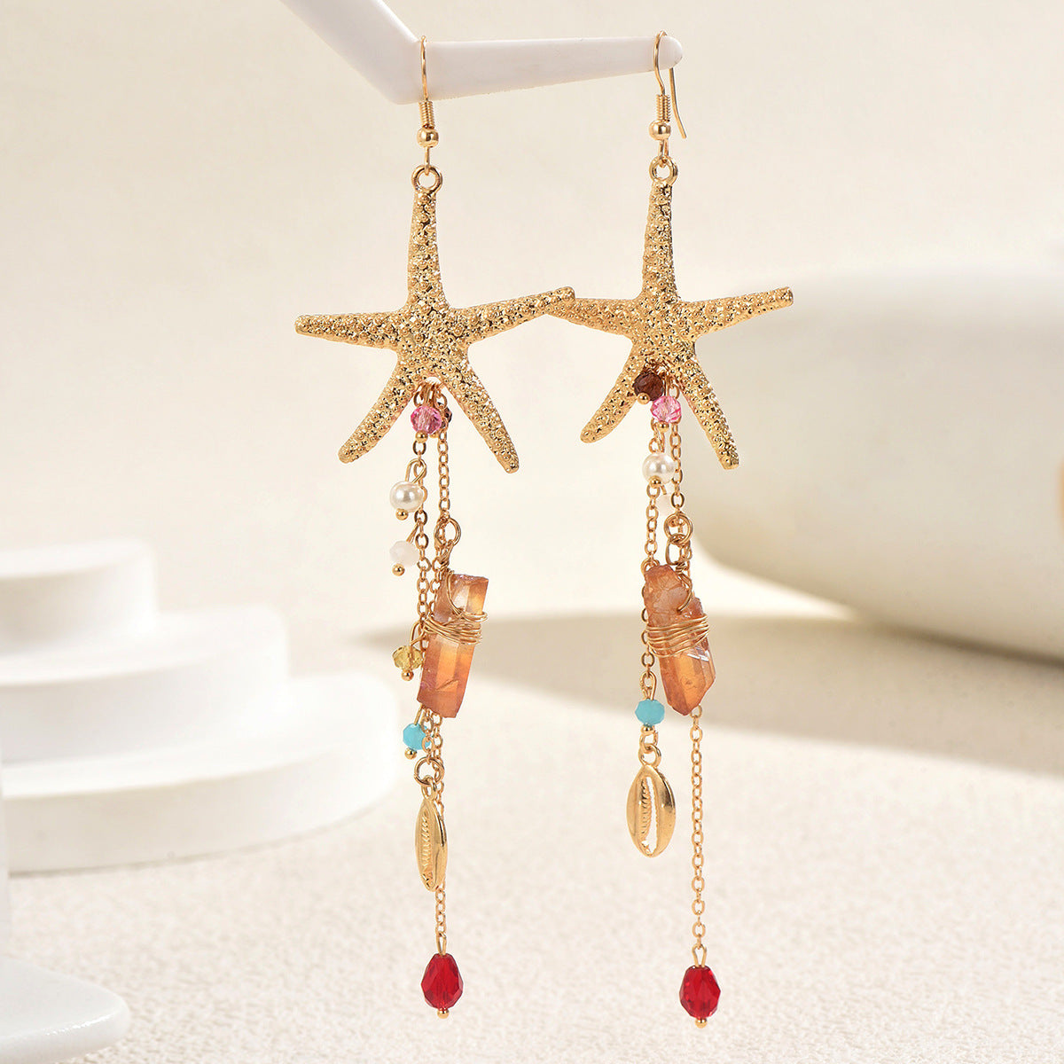 Gold starfish dangle earrings with shells beads pearls and chains ocean inspired statement jewelry for beachwear