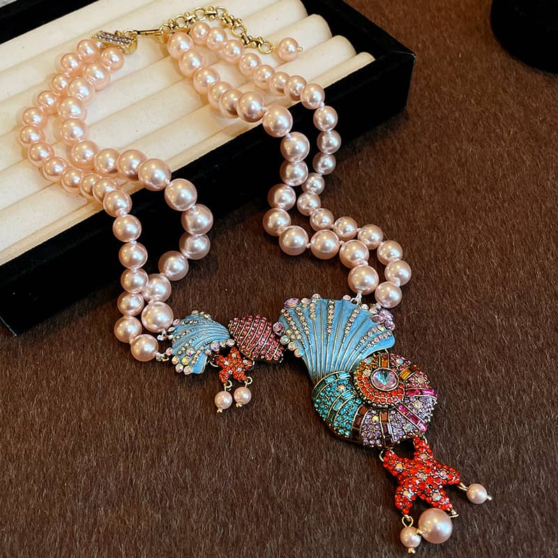 Elegant conch and pearl necklace featuring pastel colors and decorative seashell pendant
