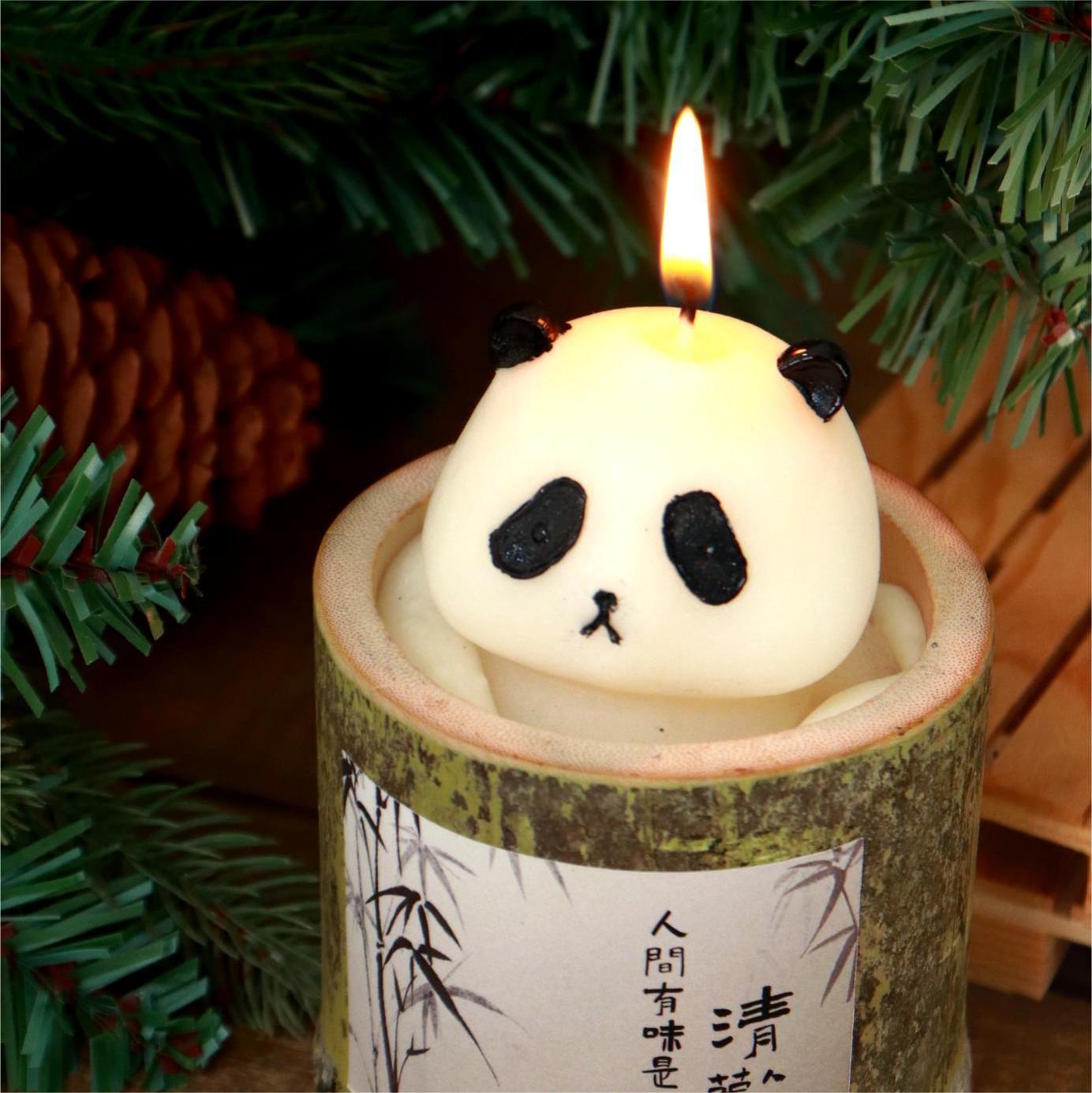 Cute animal themed candle shaped like a panda head burning inside a decorative holder