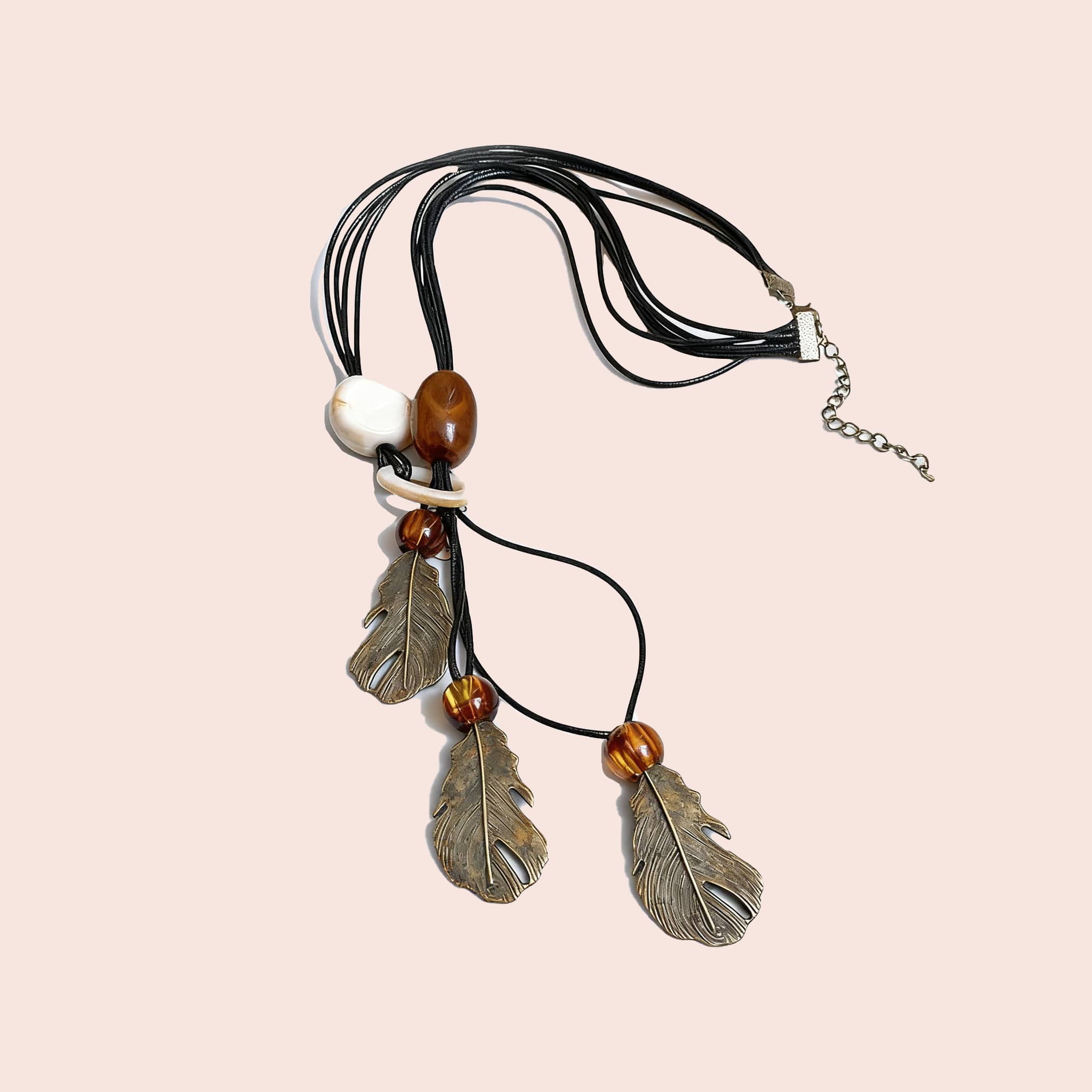 Angry earth pendant necklace featuring feather charms on a black cord with wooden beads