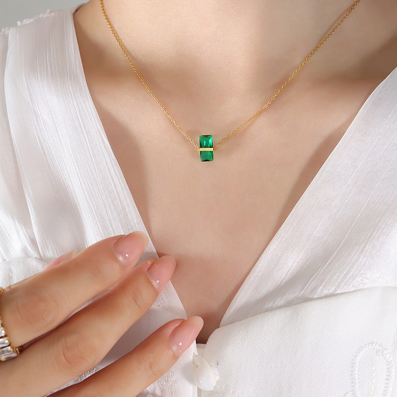 Calm emerald green pendant necklace on gold chain worn with white blouse
