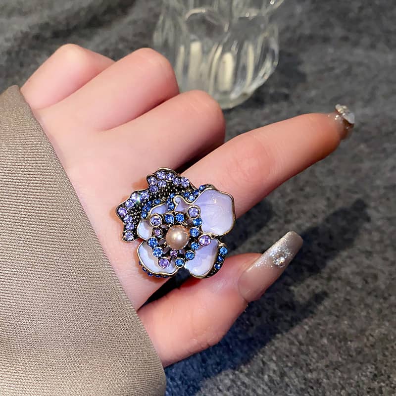Stunning enamel flower ring with pearl center adorned with sparkling gems for elegant style