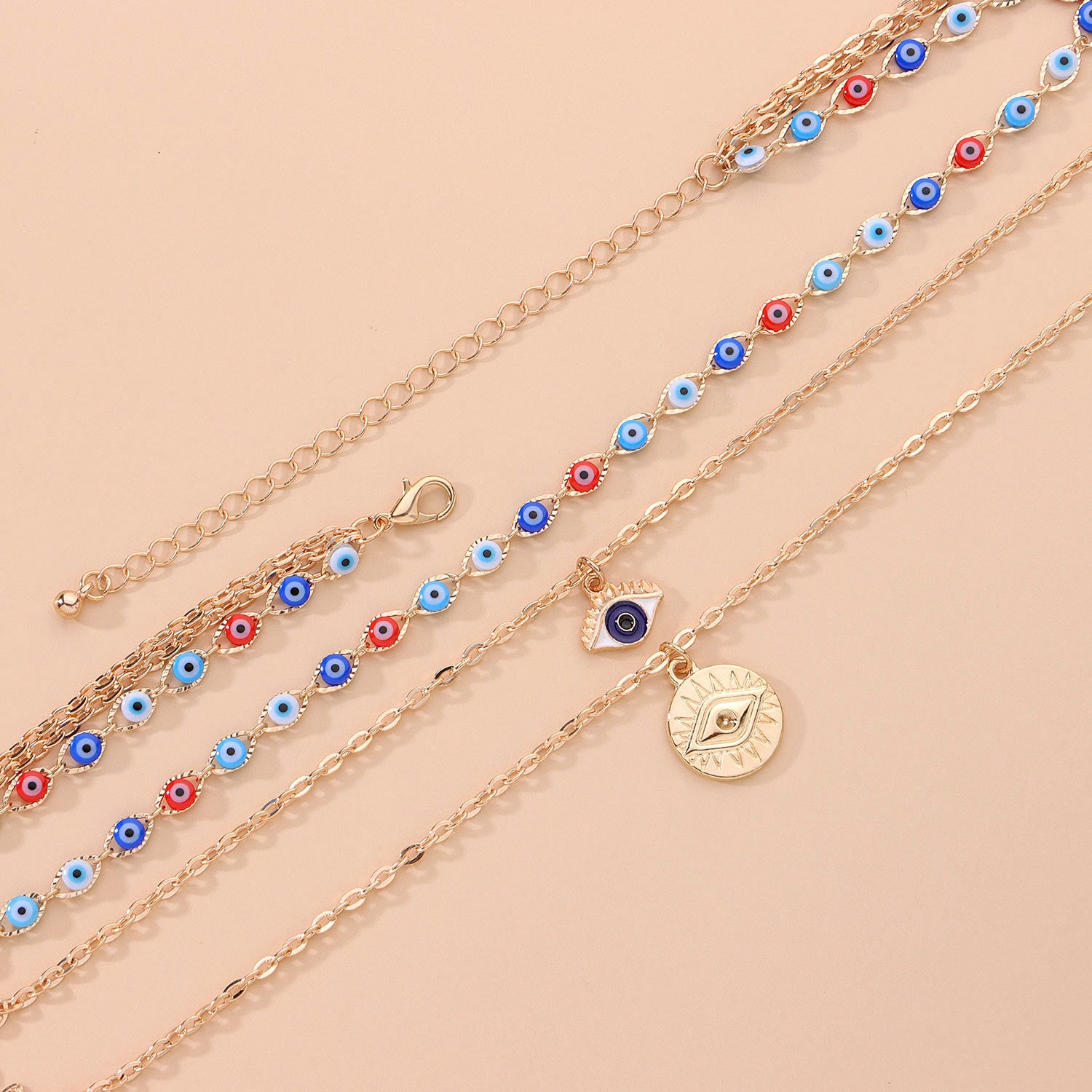 Gold chain evil eye necklace for anxiety with blue, red, and white beads on beige background