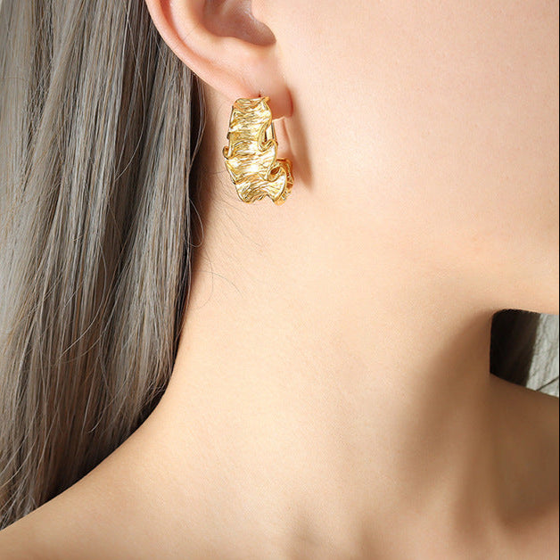 Fierce gold pleated earrings for women worn on ear with textured design