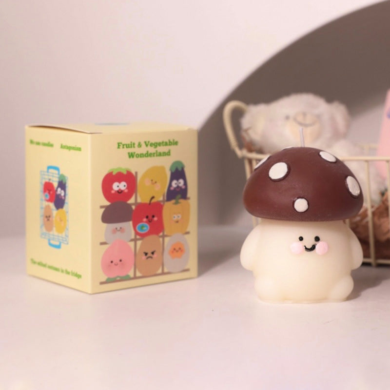Cute mushroom shaped hyper realistic food candle with smiling face next to fruit and vegetable themed packaging