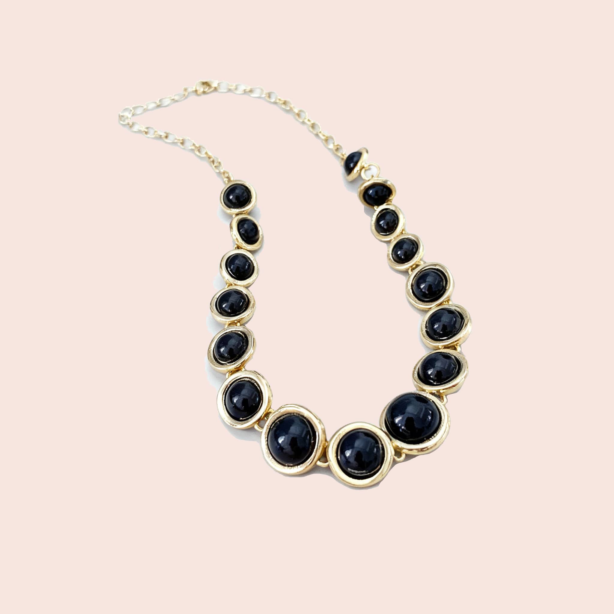 Geometric resin pendant necklace featuring black stones and gold accents for a stylish look