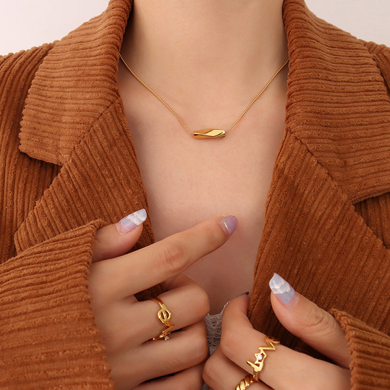 Angry necklace featuring a delicate 18K gold steel necklace worn with gold rings and a brown corduroy jacket
