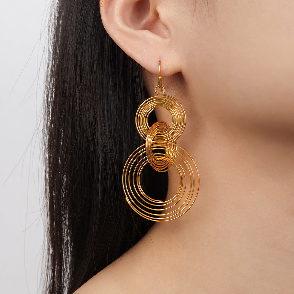 Gold circular linked earrings worn on ear anxiety calming jewelry with a modern design