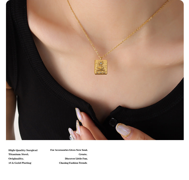 Gold solar guardian pendant necklace on model wearing black top with manicured nails