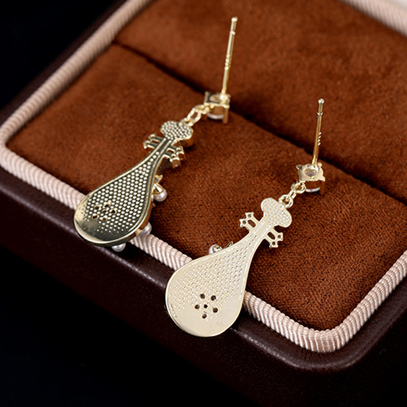 Calm gold-tone musical instrument shaped floral statement earrings for women in jewelry box