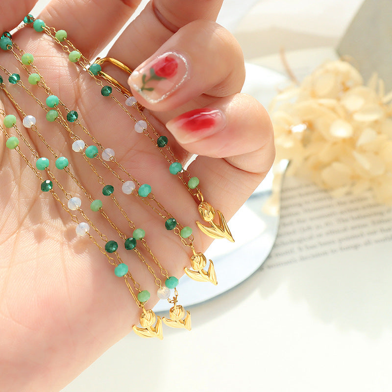 Calm necklace featuring delicate green and clear bead jewelry with gold heart charms