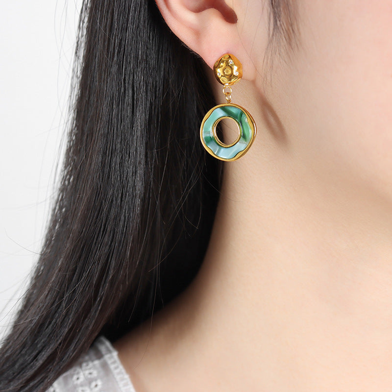 Calm green lake reflection earrings with gold accents worn on ear for elegant style