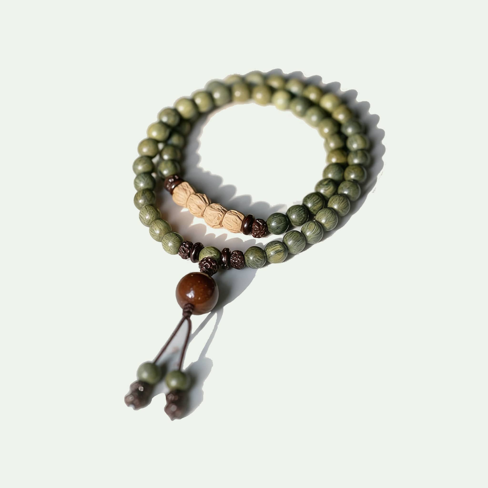 Green sandalwood mala bracelet with smooth beads and decorative accents for meditation and relaxation