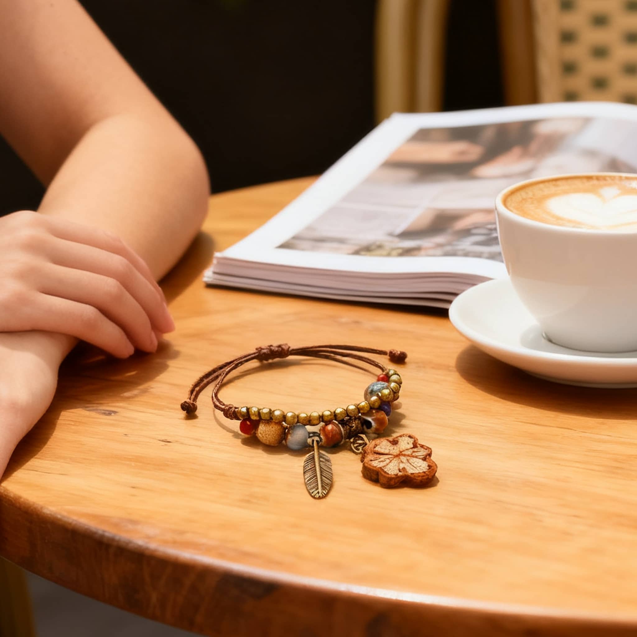 Handmade ceramic botanical bracelet featuring earthy beads and a leaf charm on a wooden table