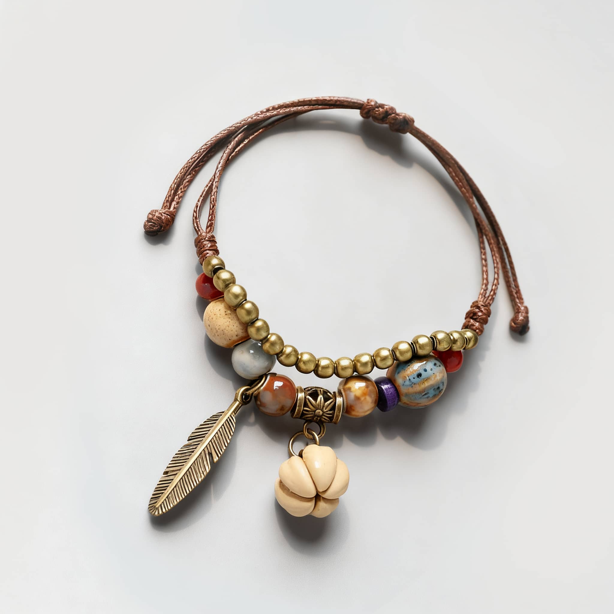 Handcrafted hawthorn seed ceramic bracelet with colorful beads and a feather charm
