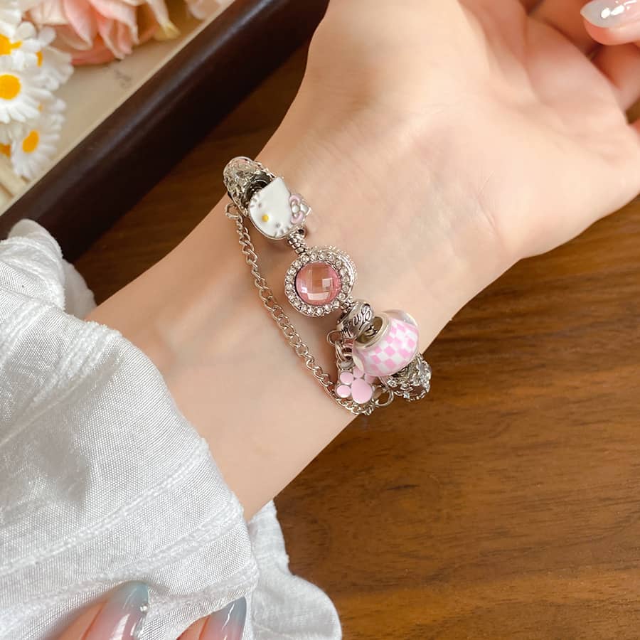 Joyful cat charm bracelet with colorful charms and silver accents worn on a wrist