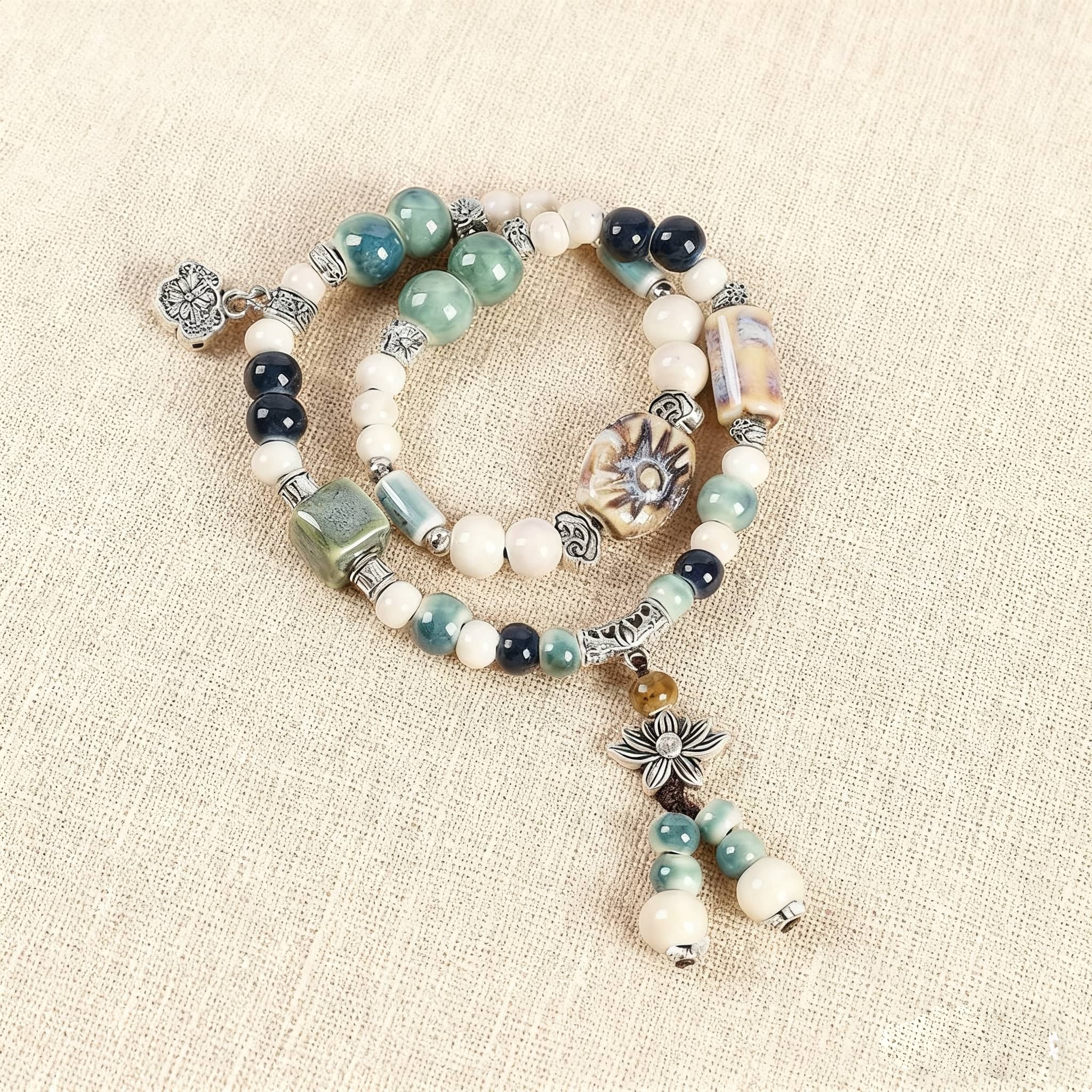 Elegant lotus ceramic bead bracelet featuring assorted beads and a charming lotus charm