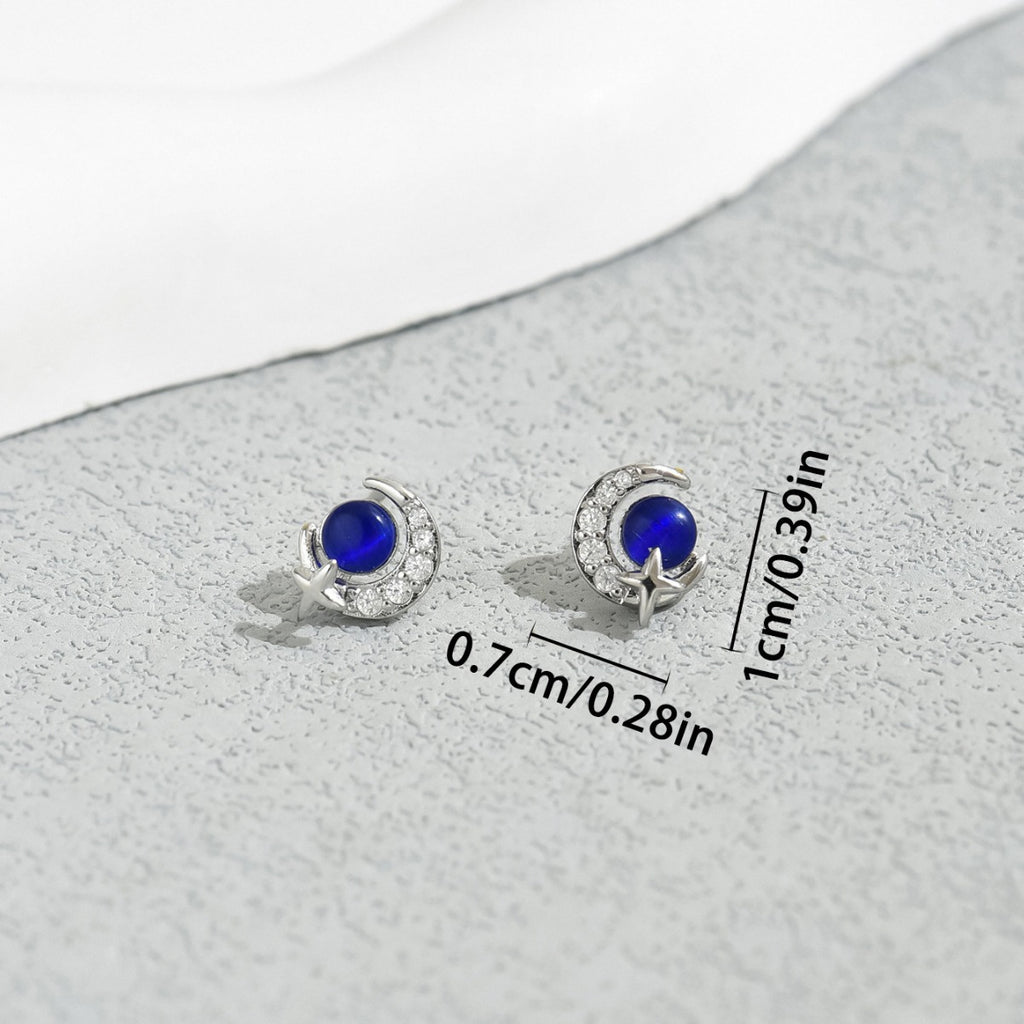 Delicate sterling silver crescent moon star stud earrings with deep blue cabochon center and cubic zirconia accents