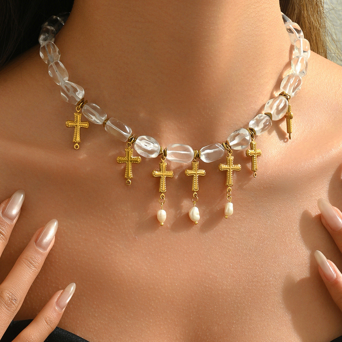 Close up of woman wearing a gold cross pearl necklace choker with clear beads and dangling pearls