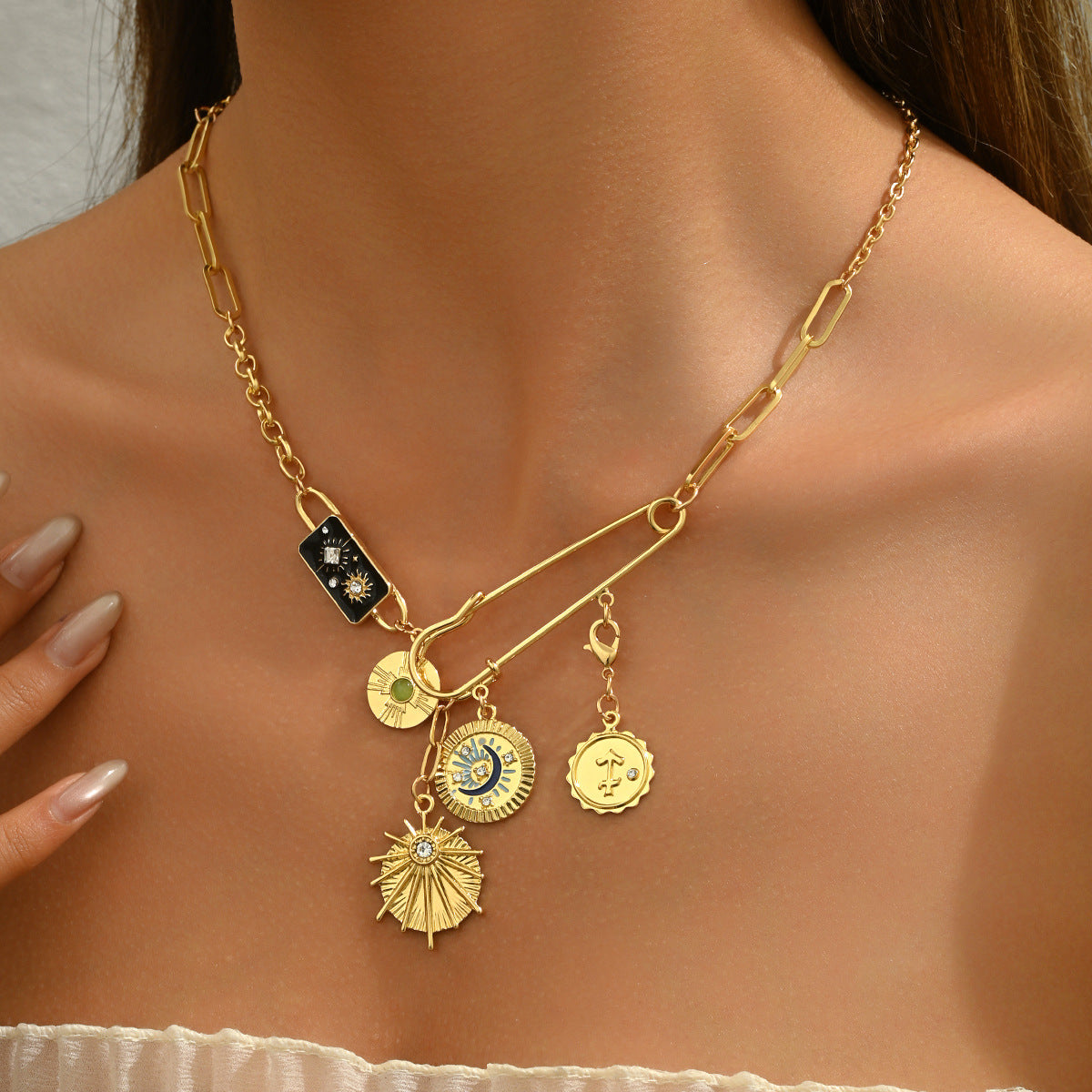 gold sun moon pendant necklace worn by model layered link chain with celestial sun moon and coin charms