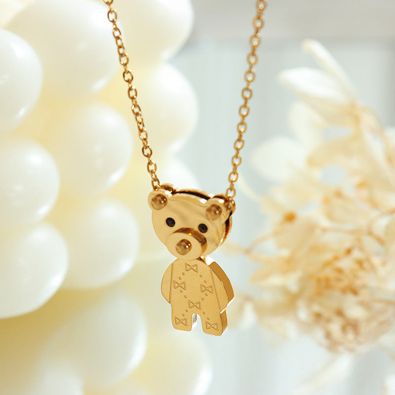 golden teddy bear necklace pendant on delicate chain with engraved bow pattern and polished gold finish