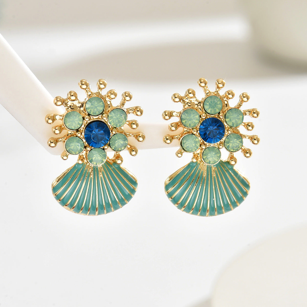 Gold sunburst earrings with blue center gems and ribbed enamel scallop shells geometric green shell drop earrings