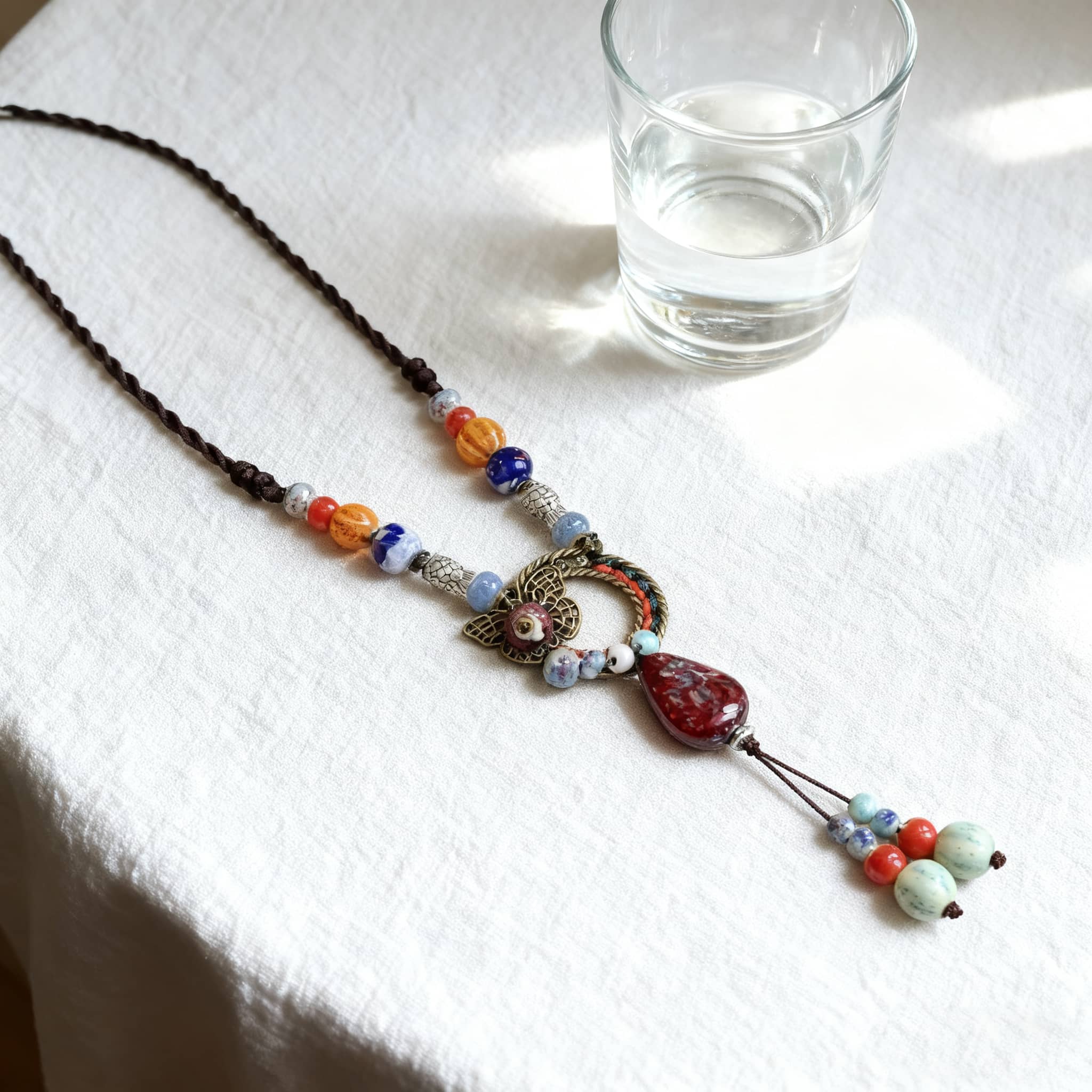 Meaningful ceramic and linen necklace featuring colorful beads and a unique pendant design