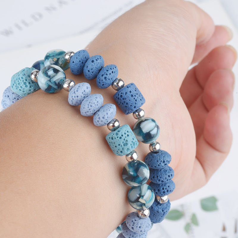 Mens healing lava rock bracelet in shades of blue with silver beads worn on wrist