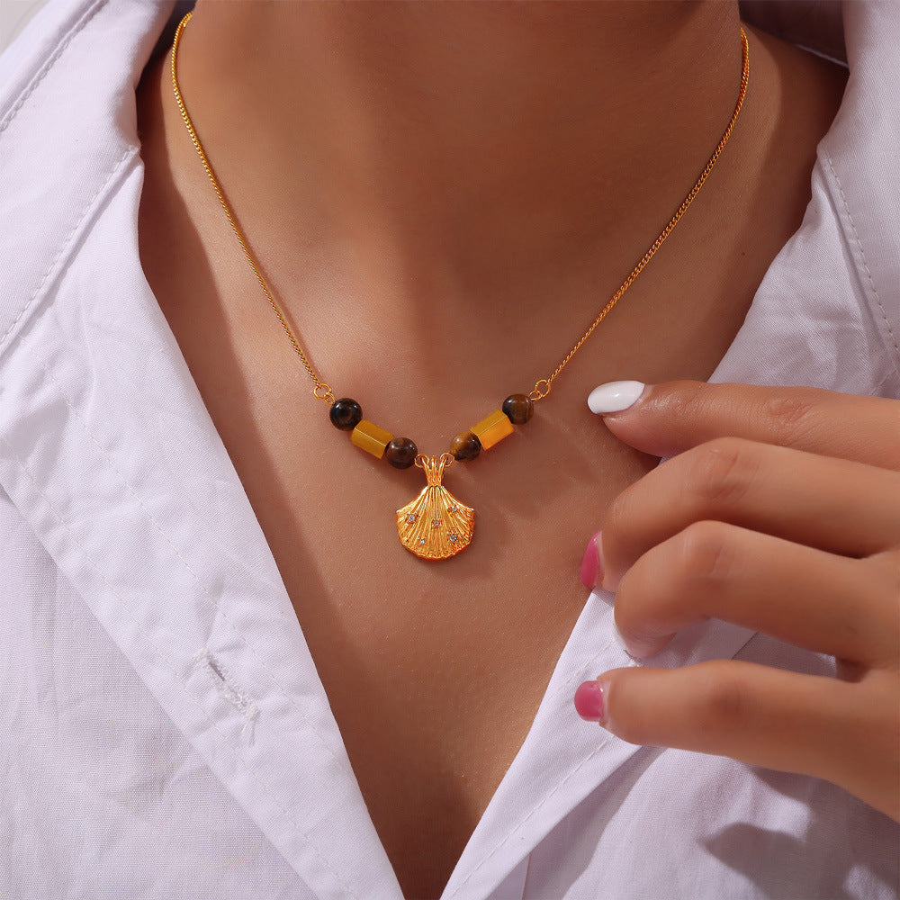 Gold necklace with tiger's eye beads and shell pendant showcasing tiger's eye jewelry for confidence
