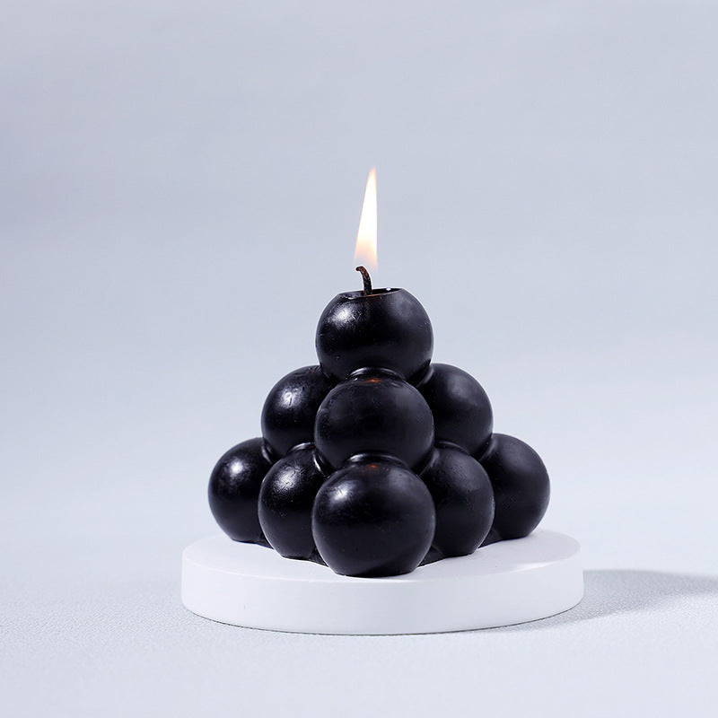 modern decorative aromatherapy candle shaped like stacked black spheres on a white base