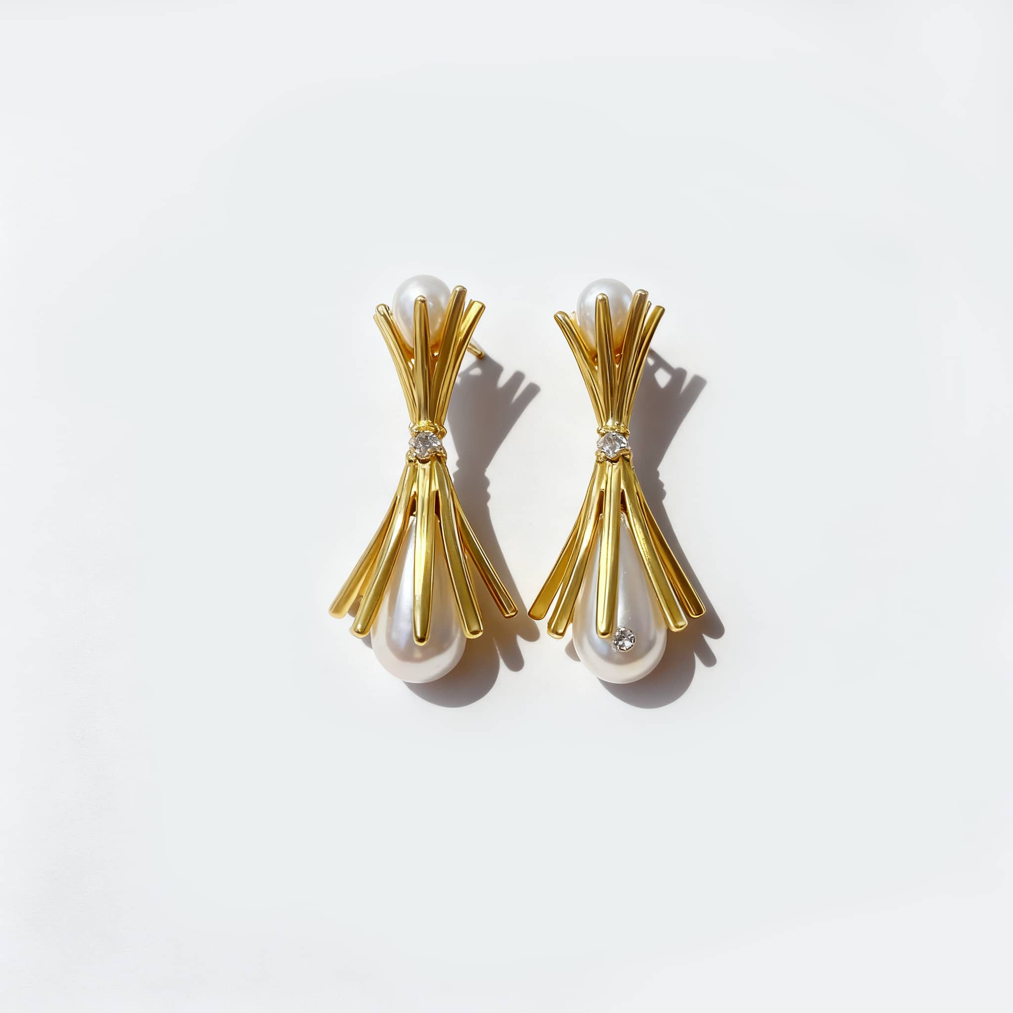 Elegant pearl and gold bouquet earrings featuring a modern design and sparkling accents