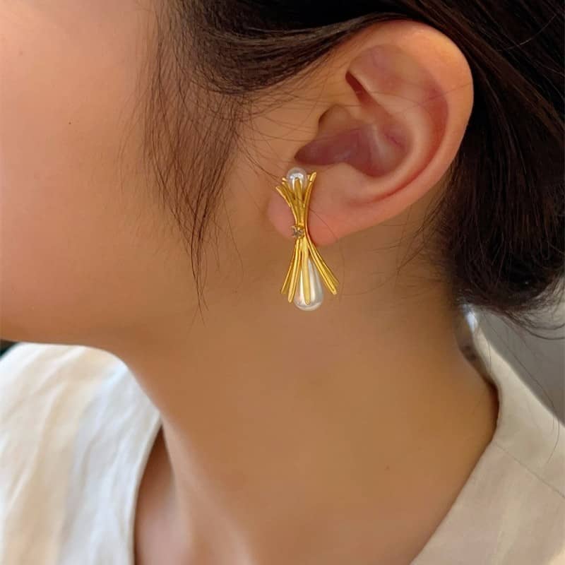 Elegant pearl and gold bouquet earrings showcased on a model's ear for a sophisticated look