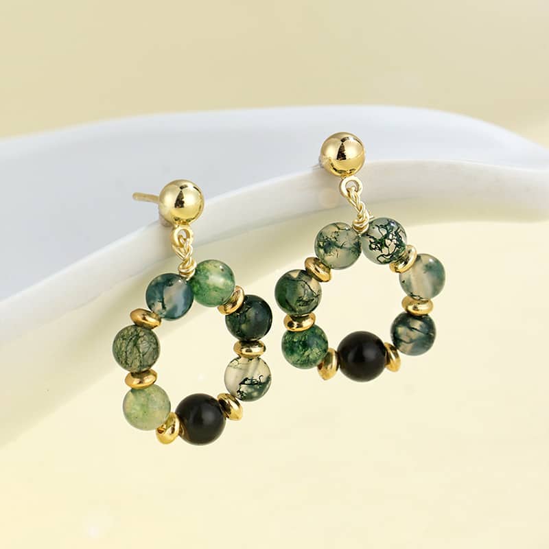 Moss agate anxiety earrings with gold accents featuring a mix of green and black stones