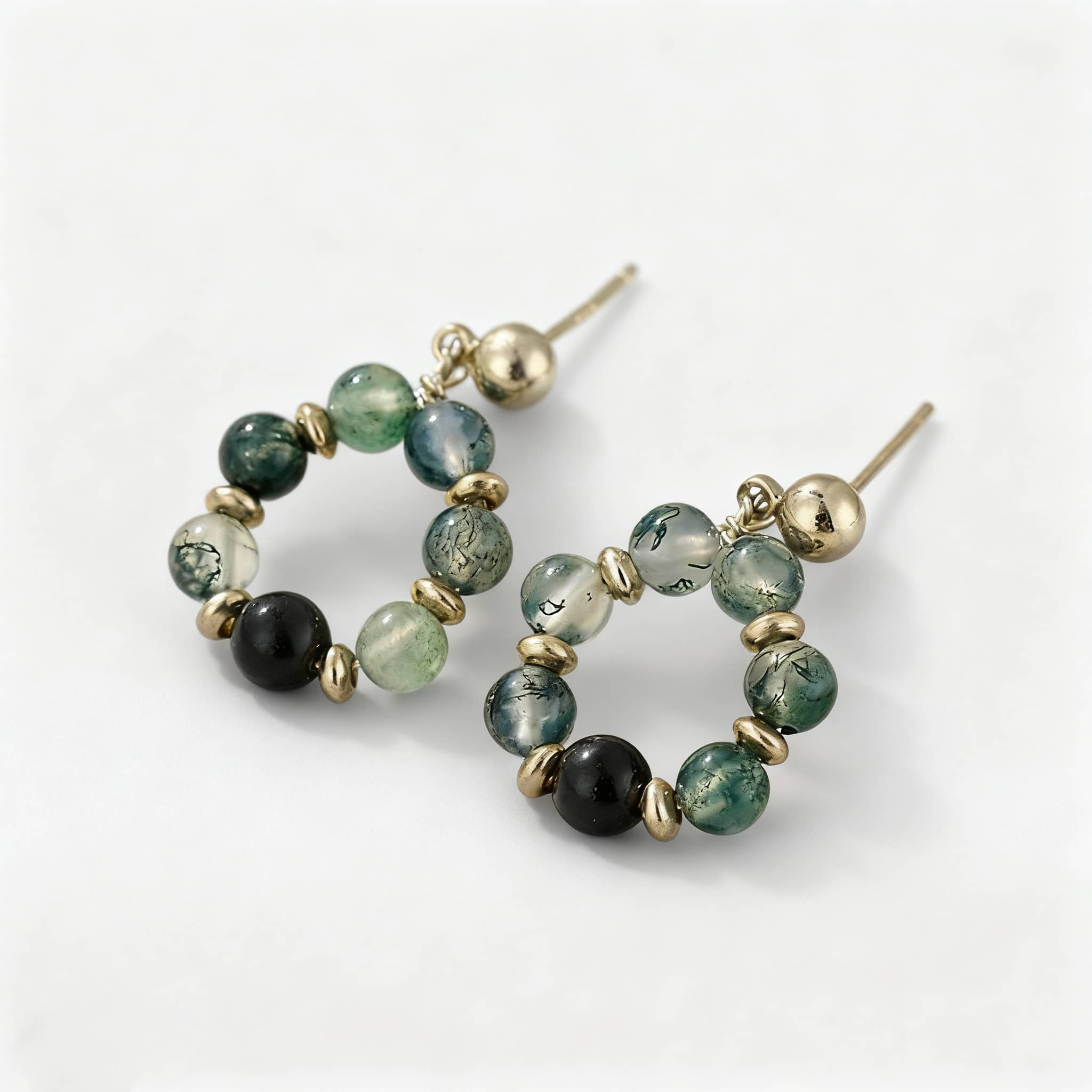 Moss agate anxiety earrings with gold accents, showcasing calming green and black stones in a hoop design