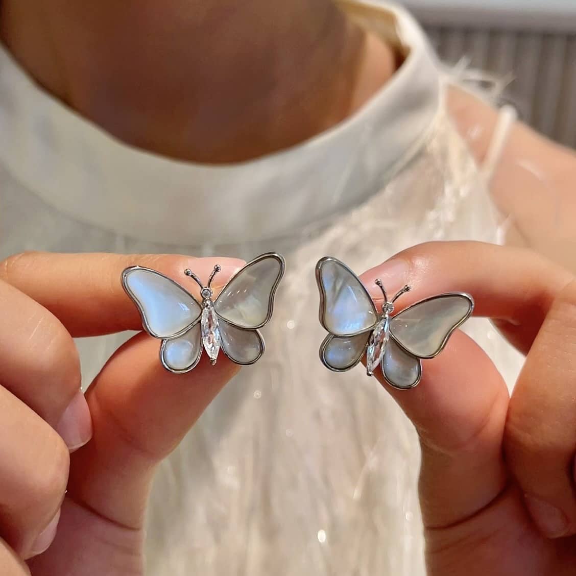 Elegant mother of pearl butterfly earrings featuring delicate details and sparkling accents