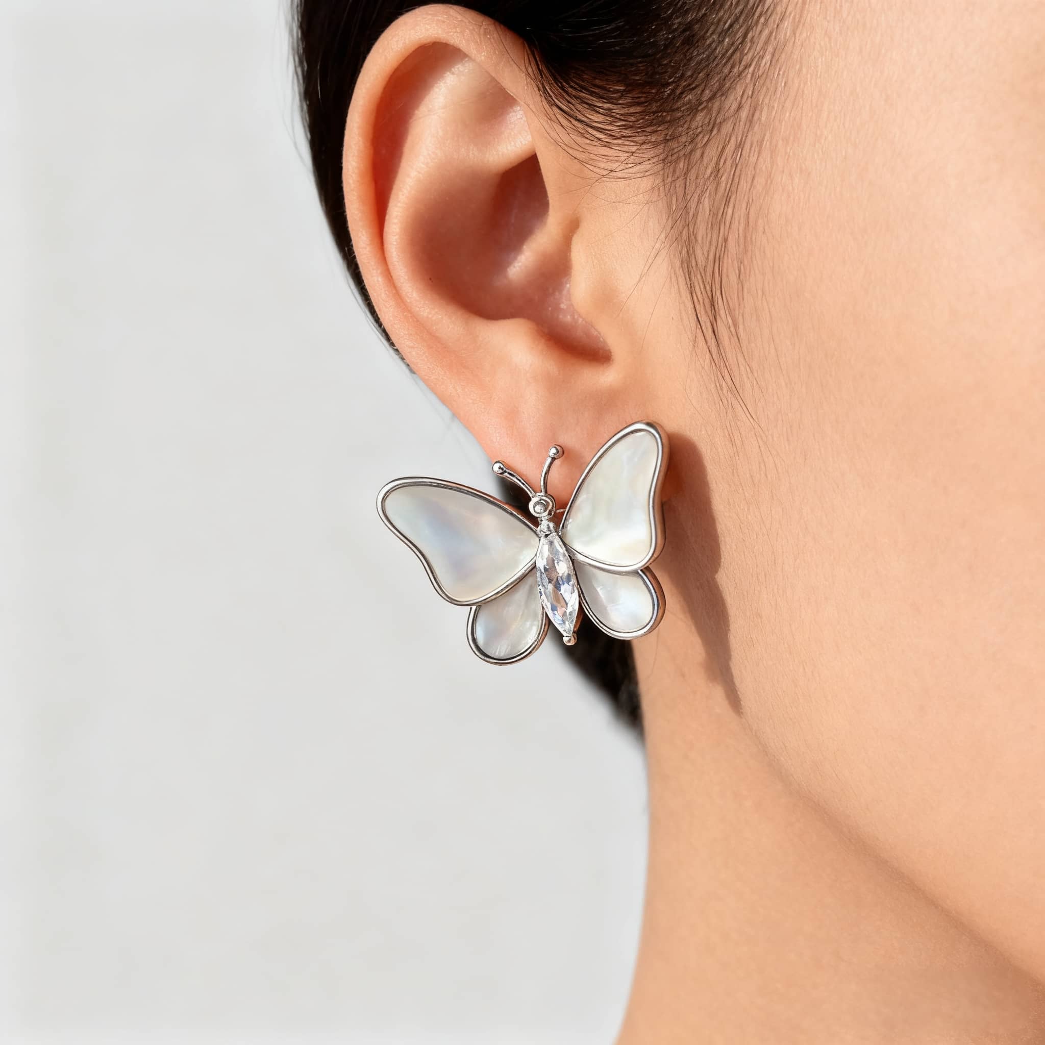 Elegant mother of pearl butterfly earrings with a shiny crystal accent for a sophisticated look