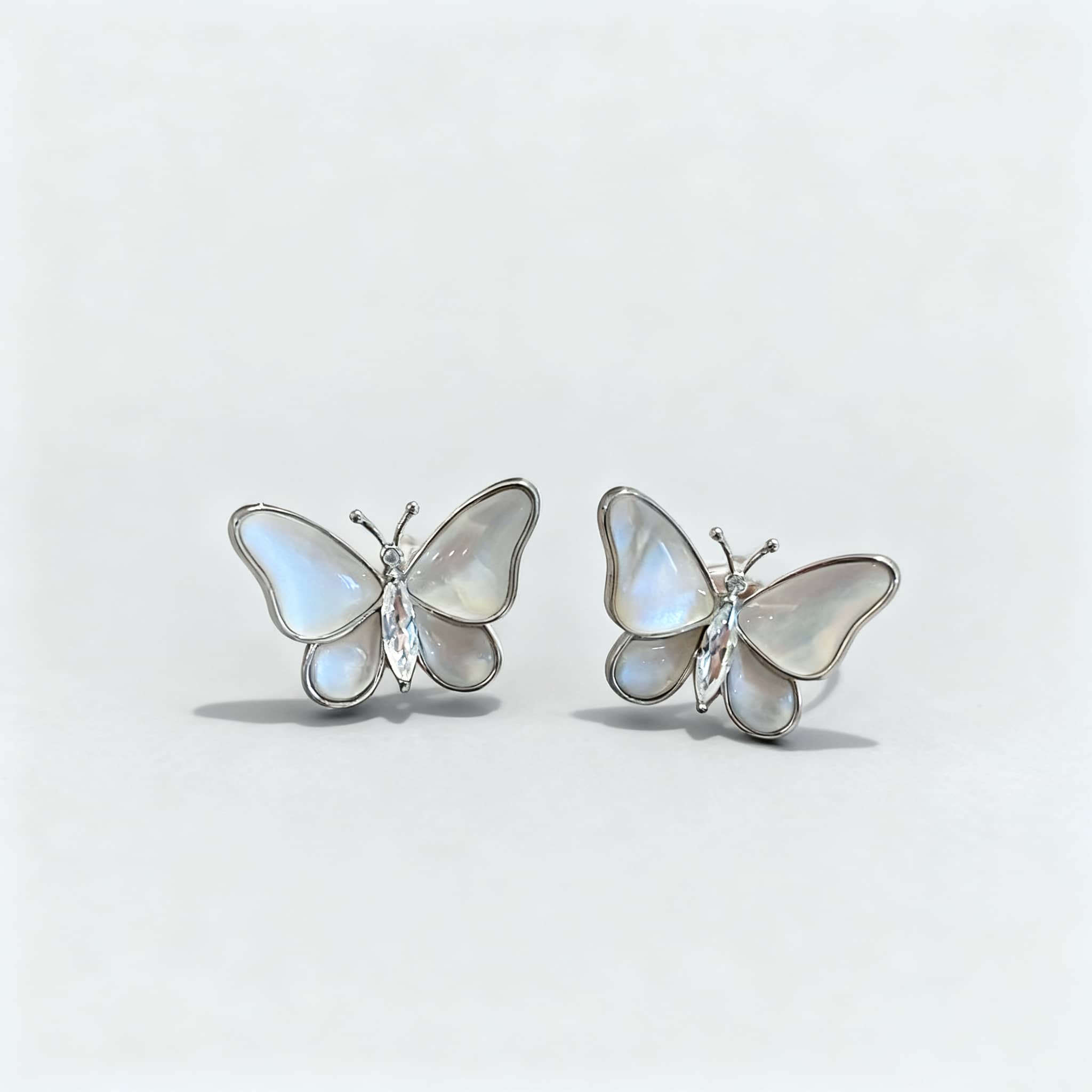 Insecure mother of pearl butterfly earrings featuring intricate floral designs with natural stones