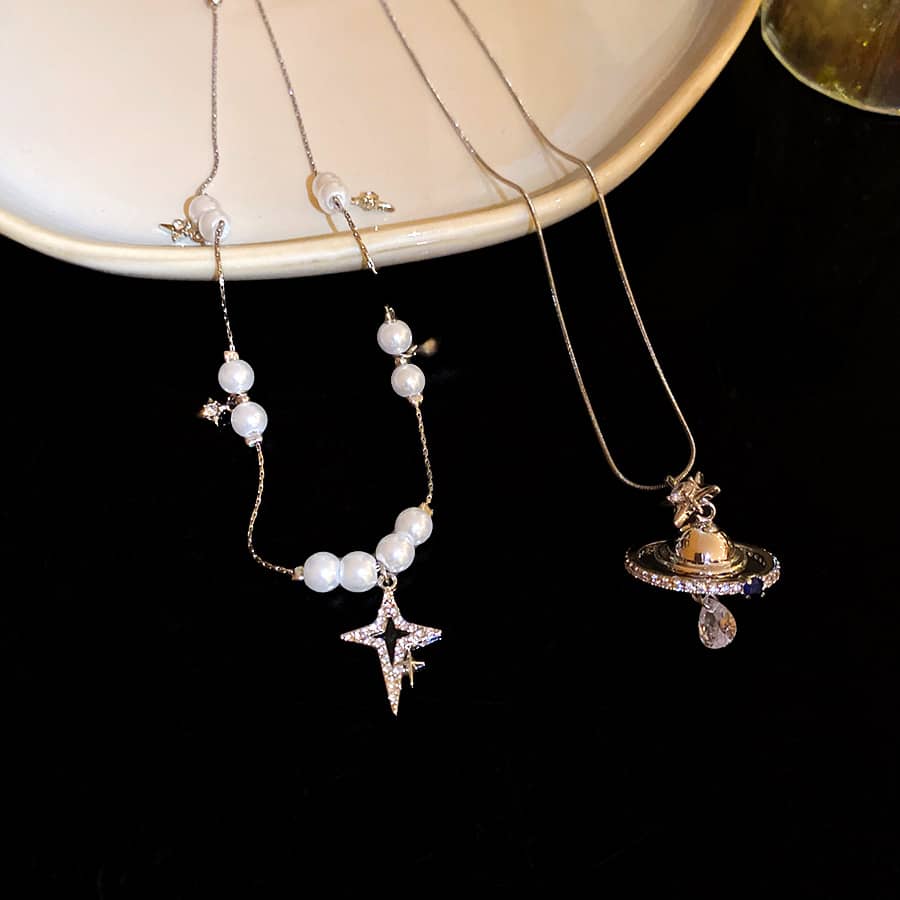 Elegant pearl and Saturn pendant necklace featuring star and pearl accents for a chic look