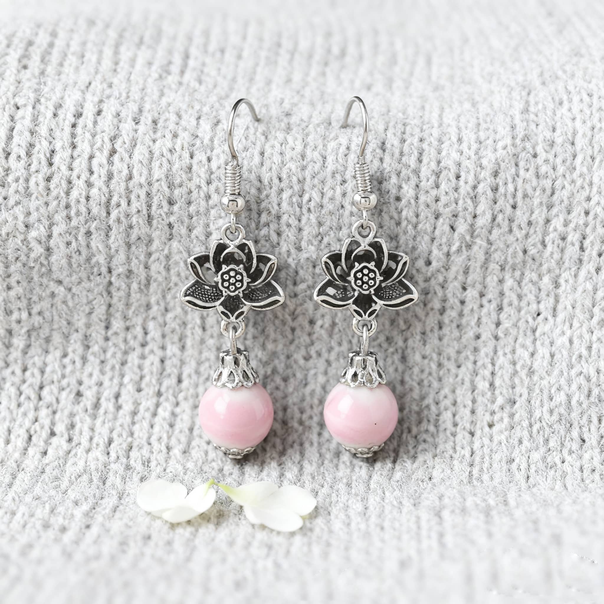 Elegant pink ceramic lotus earrings with silver floral details, perfect for adding a touch of style